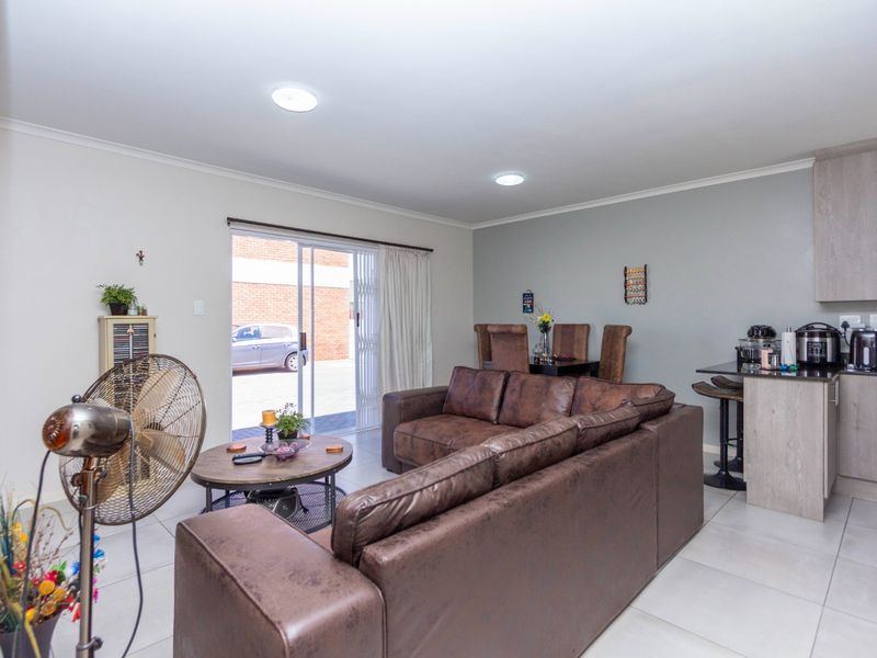 Open-plan living and dining area featuring tiled floors, recessed lighting, and a modern kitchen with granite countertops and breakfast bar.