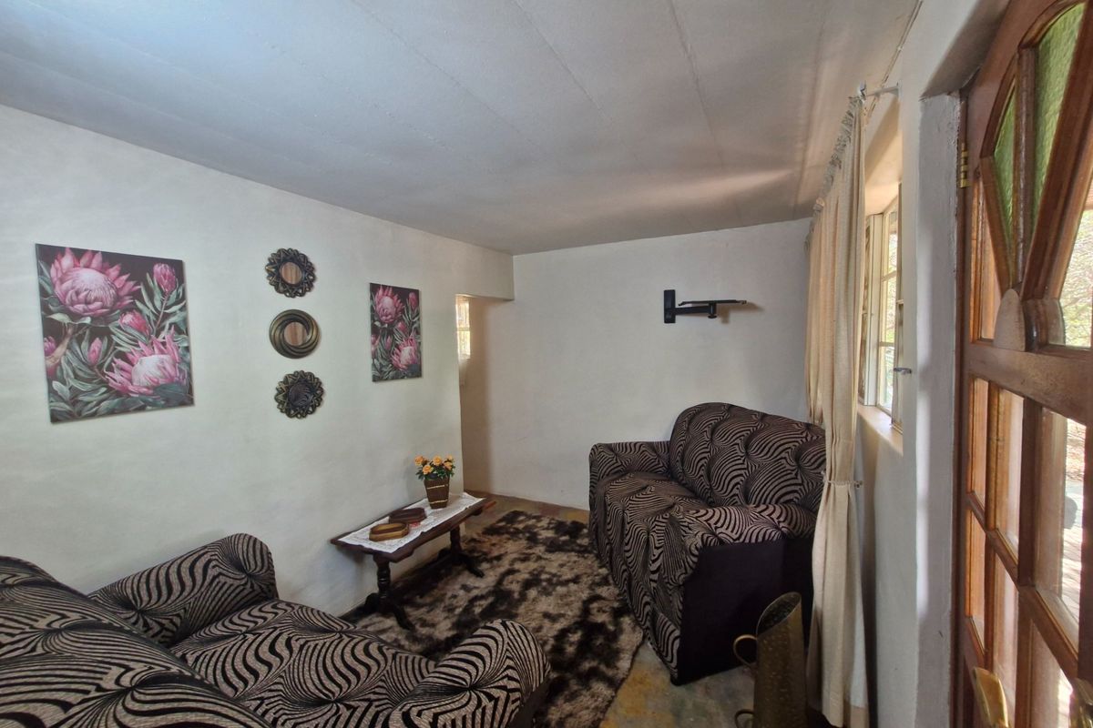 A living room area featuring a timber framed glass door and wall-mounted television bracket, requiring cosmetic updates to improve the overall finish.