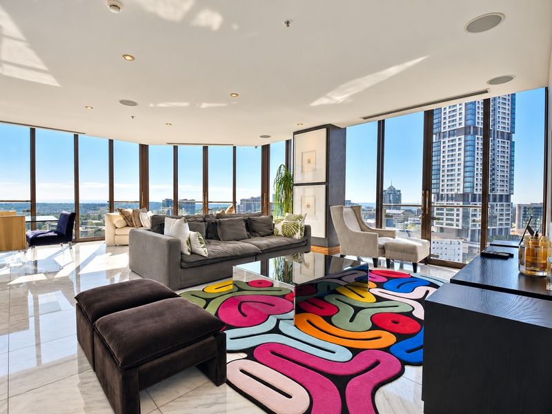 Spacious living area featuring floor-to-ceiling windows with panoramic city views, polished marble flooring, and modern recessed lighting.