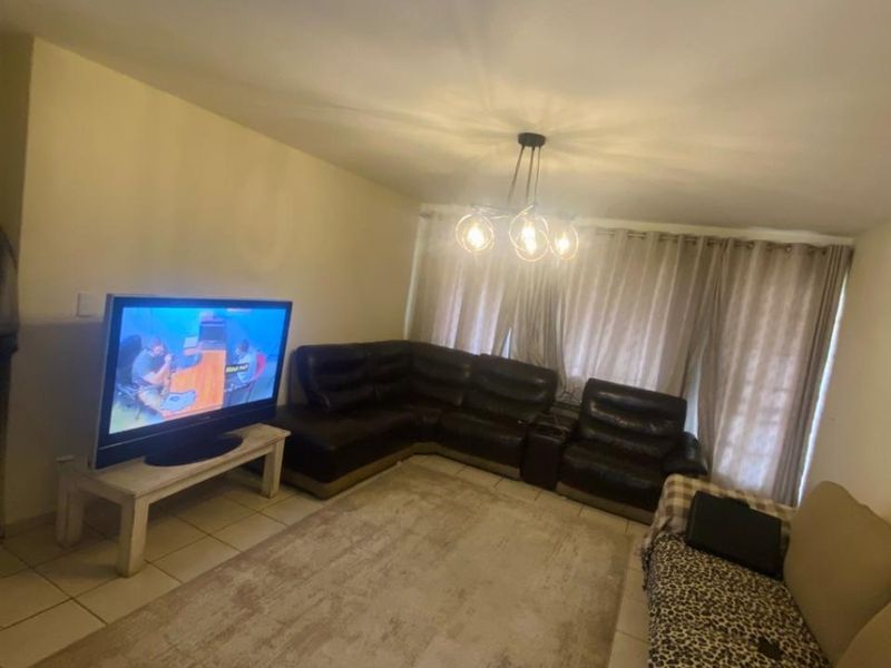 A living room featuring tiled flooring and a central ceiling light fixture, providing a functional space for relaxation.