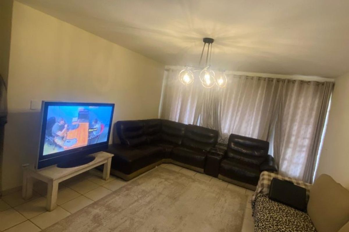A living room featuring tiled flooring and a central ceiling light fixture, providing a functional space for relaxation.
