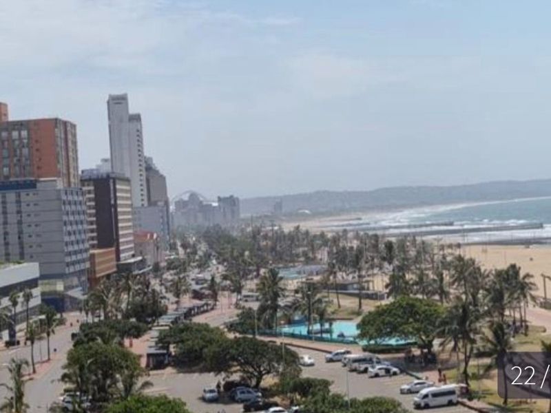 Elevated coastal city view overlooking the beach, promenade, and surrounding urban infrastructure.
