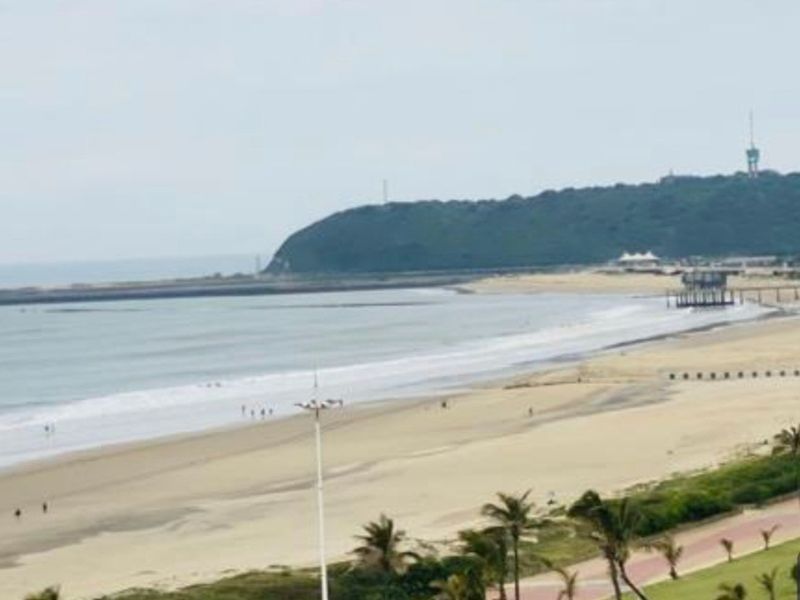 A scenic elevated view overlooking the coastline, beach, and ocean.