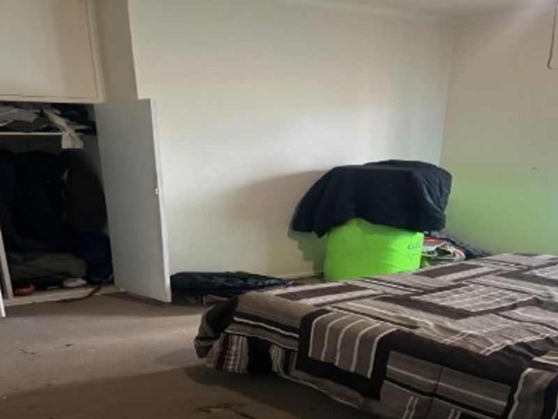 A bedroom featuring a built-in wardrobe and carpeted flooring, requiring cosmetic updates to improve the overall condition and appeal.