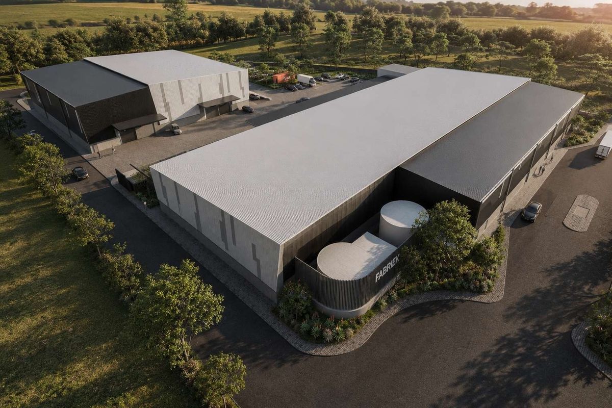 Aerial view of a modern industrial warehouse complex featuring multiple buildings, paved parking, and landscaped grounds in a rural setting.