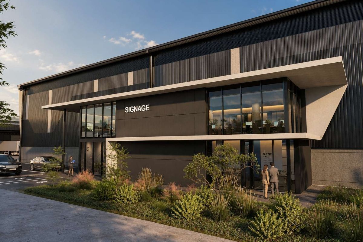 Modern industrial building facade featuring dark metal cladding, expansive glass windows, and a sleek concrete canopy entrance with dedicated parking.