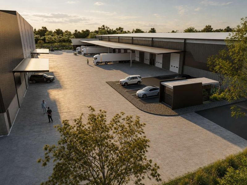 Aerial view of a modern industrial warehouse complex featuring extensive concrete yard space, multiple loading docks, and a dedicated security gatehouse.
