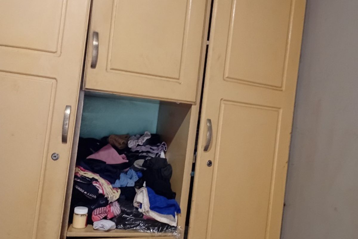 A bedroom featuring a built-in wardrobe with multiple storage compartments and cabinet doors.