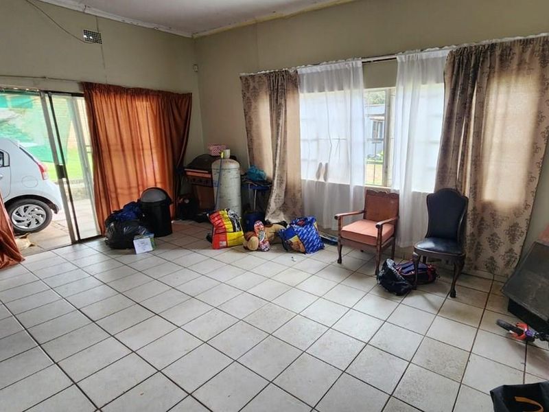 Living room featuring tiled flooring, a built-in fireplace, and a sliding glass door providing access to the exterior.