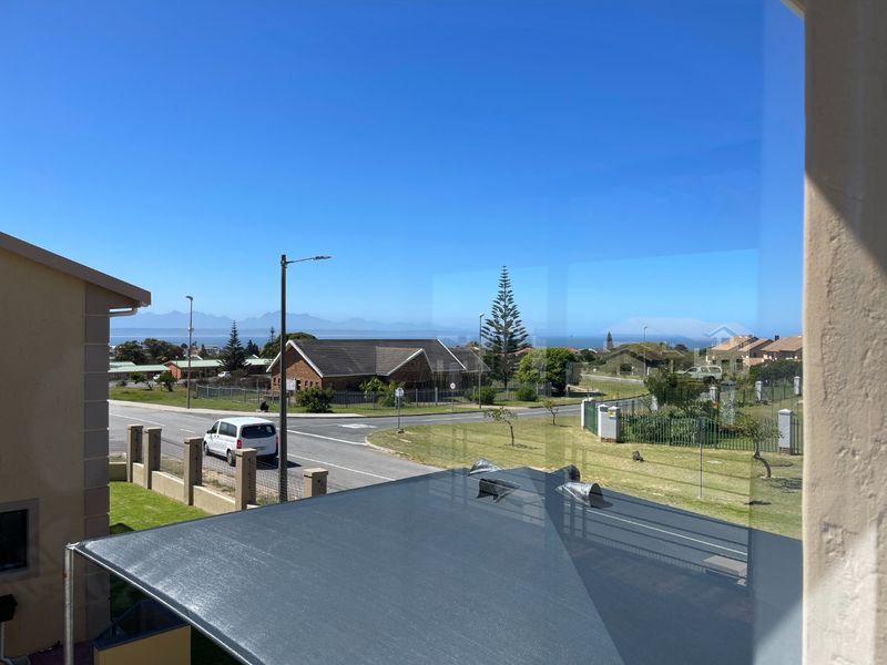 A clear elevated view of the surrounding neighbourhood and distant mountain range captured from an interior window.