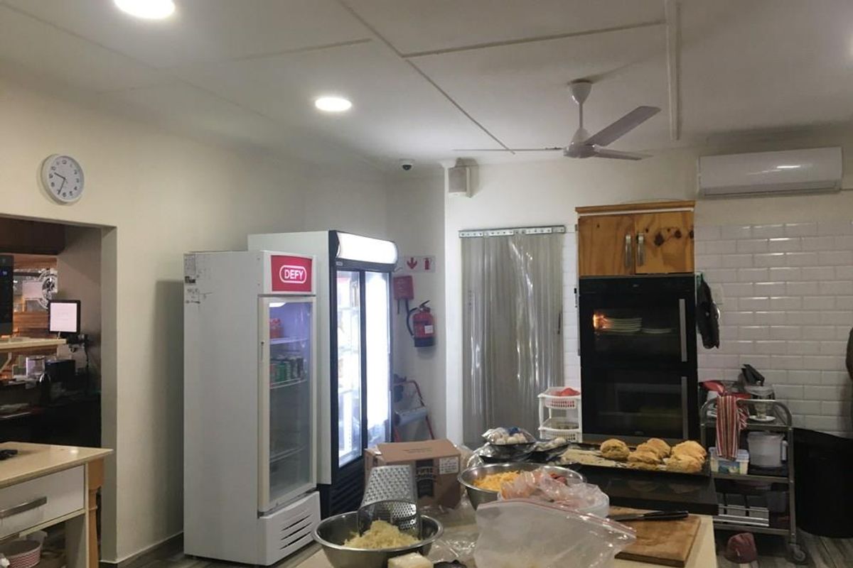 Commercial kitchen area featuring a built-in double oven, subway tile backsplash, recessed lighting, and integrated air conditioning unit.