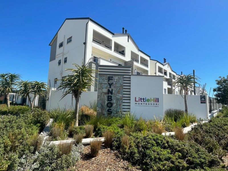Front exterior view of the Fynbos apartment complex, featuring modern architecture, landscaped gardens, and secure perimeter fencing.