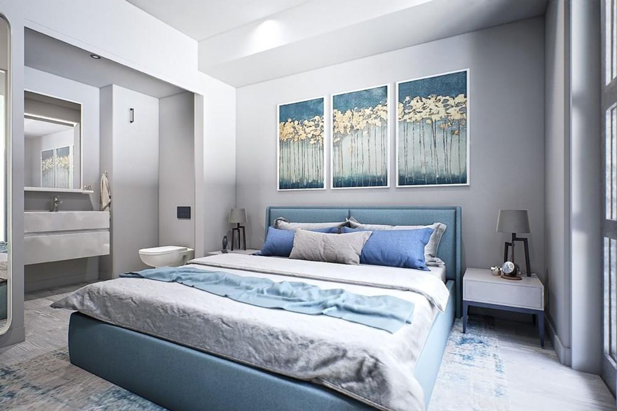 A modern bedroom featuring an integrated en-suite bathroom with a wall-mounted vanity and toilet, showcasing contemporary finishes and clean architectural lines.