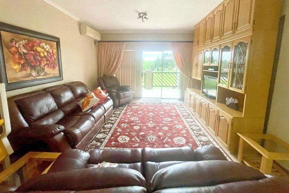 A living room featuring built-in wooden cabinetry and a sliding glass door leading to an outdoor balcony area.
