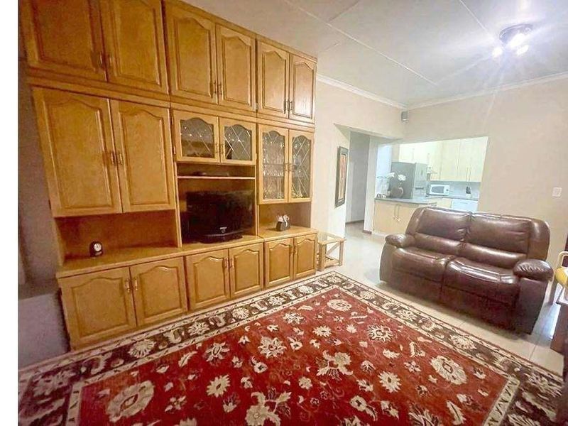 Open plan living area featuring tiled flooring and a view through to the kitchen area.