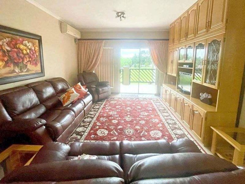 A living room featuring built-in wooden cabinetry and a sliding glass door leading to an outdoor balcony area.