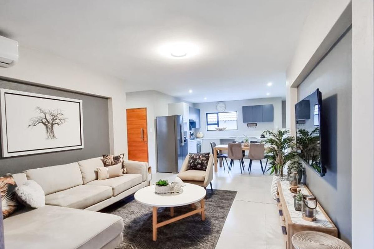 Open-plan living and dining area featuring tiled flooring, modern neutral finishes, and a seamless flow into the kitchen space.