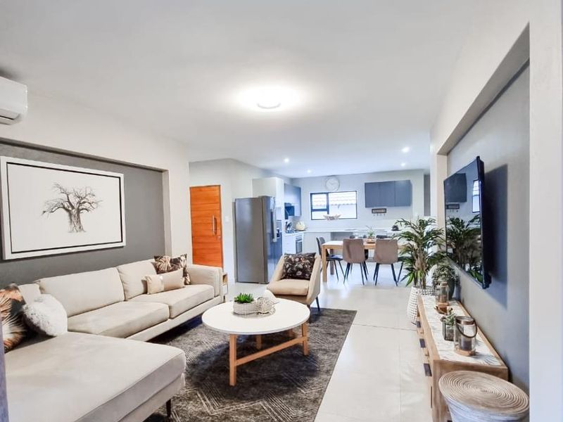 Open-plan living and dining area featuring tiled flooring, modern neutral finishes, and a seamless flow into the kitchen space.