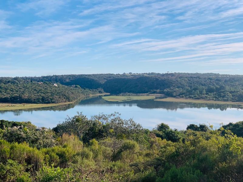 A scenic elevated view overlooking a tranquil river and surrounding natural landscape, showcasing the peaceful environment of the vacant land.