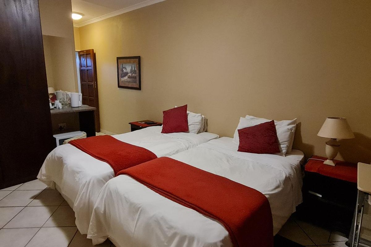 A functional bedroom featuring tiled flooring, a built-in wardrobe, and an integrated air conditioning unit.