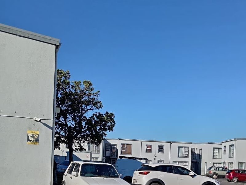 Exterior view of the apartment complex parking area and building facade.