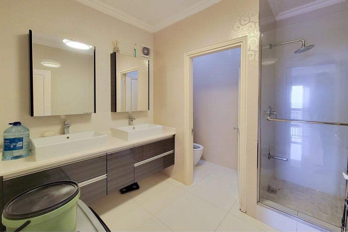 Modern bathroom featuring a double vanity with vessel sinks, wall-mounted mirrors, and a glass-enclosed walk-in shower with a rainfall showerhead.