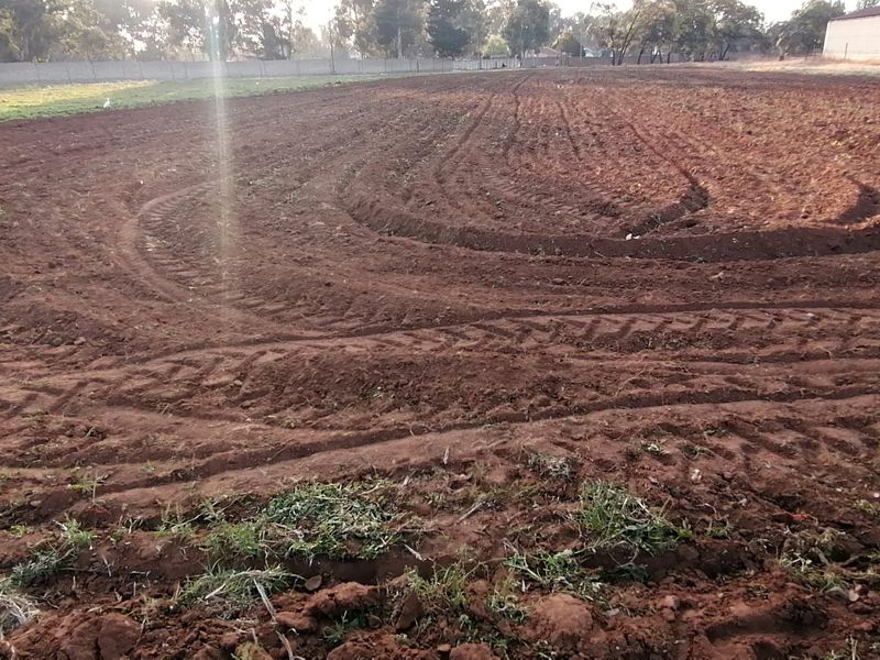A view of a large, tilled agricultural field on the farm property, showing prepared soil ready for planting.