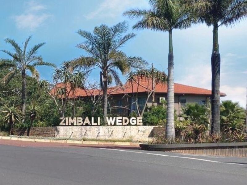 Street view of the Zimbali Wedge estate entrance featuring established palm trees and stone signage.