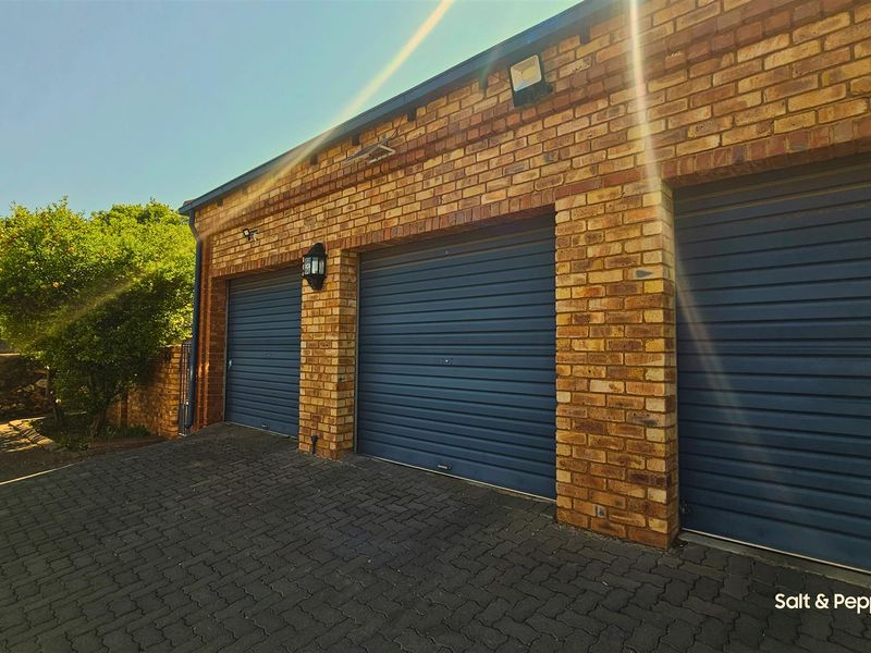 A well-maintained triple garage featuring a classic face brick exterior and paved driveway, providing secure parking and street-facing access.