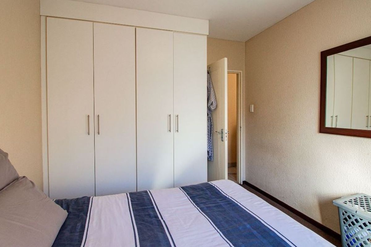 A bedroom featuring built-in cupboards and neutral wall finishes, providing functional storage space within the apartment.