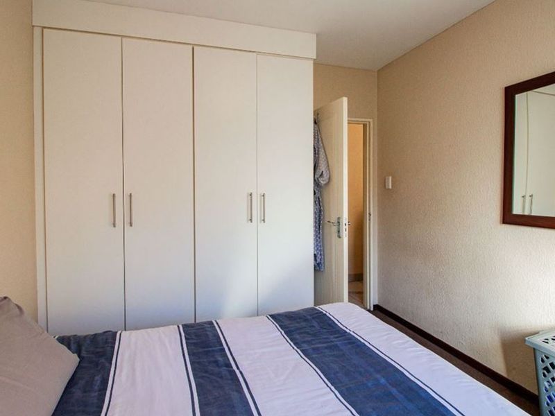 A bedroom featuring built-in cupboards and neutral wall finishes, providing functional storage space within the apartment.