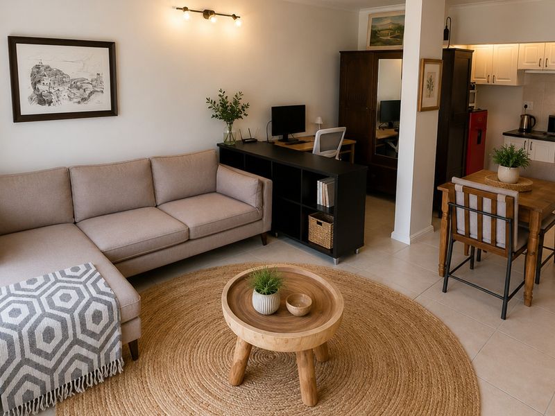 An open-plan living and kitchen area featuring tiled floors, neutral cabinetry, and a functional layout that seamlessly connects the lounge and dining space.