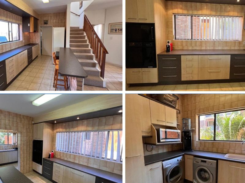 A functional kitchen featuring built-in cabinetry, tiled backsplash, and integrated appliances, with an adjacent staircase leading to the upper level.