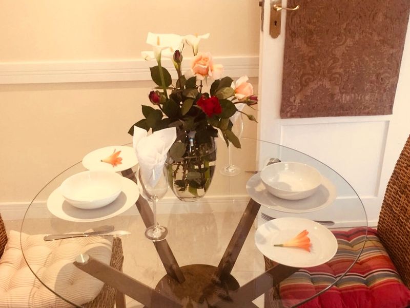 A compact dining area featuring a classic chair rail and a traditional panel door.