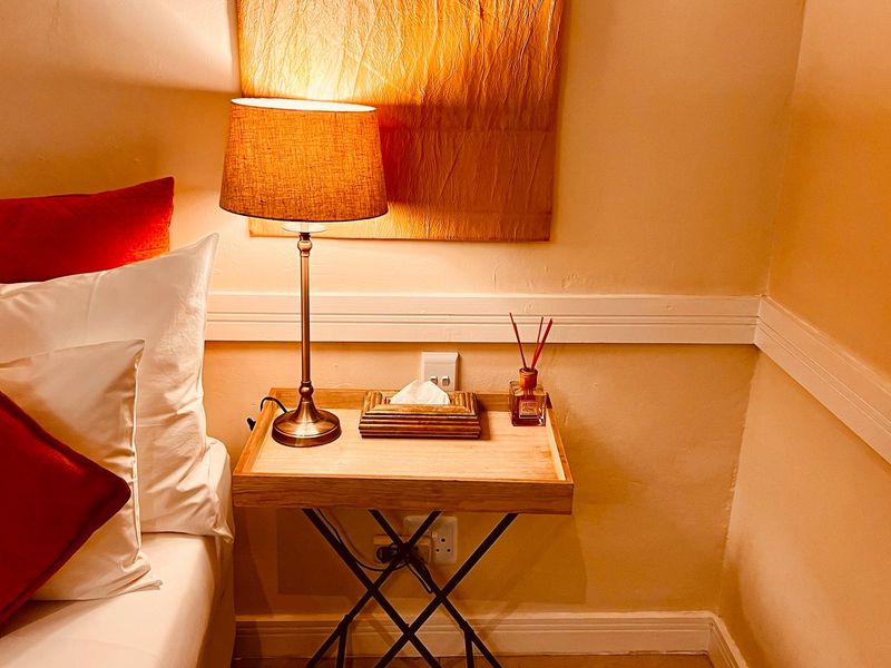 A close-up view of a bedroom corner featuring a chair rail and wall-mounted electrical outlets.