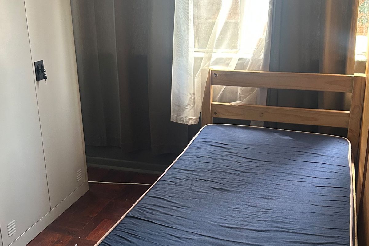 A bedroom featuring parquet flooring and a window with natural light.
