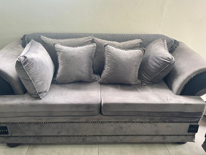A close-up view of a grey upholstered sofa in a living area.