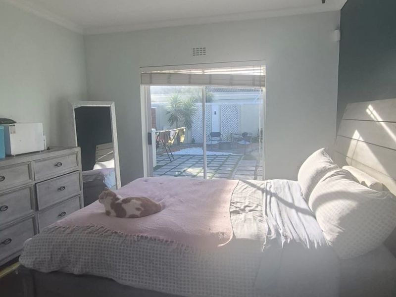 A bedroom featuring a sliding glass door that provides direct access to an outdoor patio area.