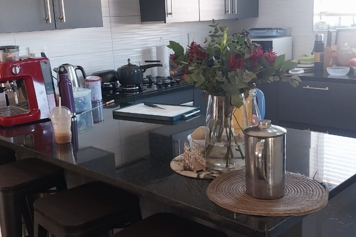 Modern kitchen featuring dark cabinetry, granite countertops, and a gas hob, providing a functional and stylish cooking space.