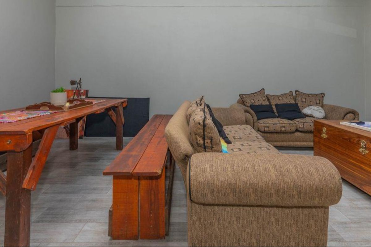 A spacious living area featuring neutral wall finishes and tiled flooring, offering a versatile layout for comfortable seating and dining arrangements.