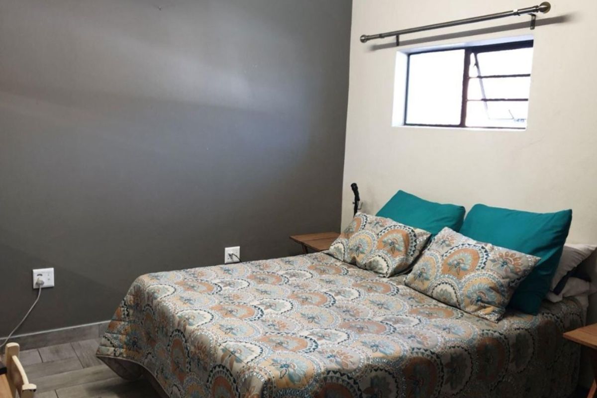 A bedroom featuring tiled flooring and a neutral wall finish, providing a functional space for rest.