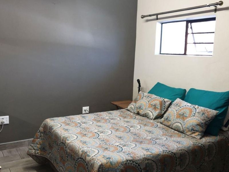 A bedroom featuring tiled flooring and a neutral wall finish, providing a functional space for rest.