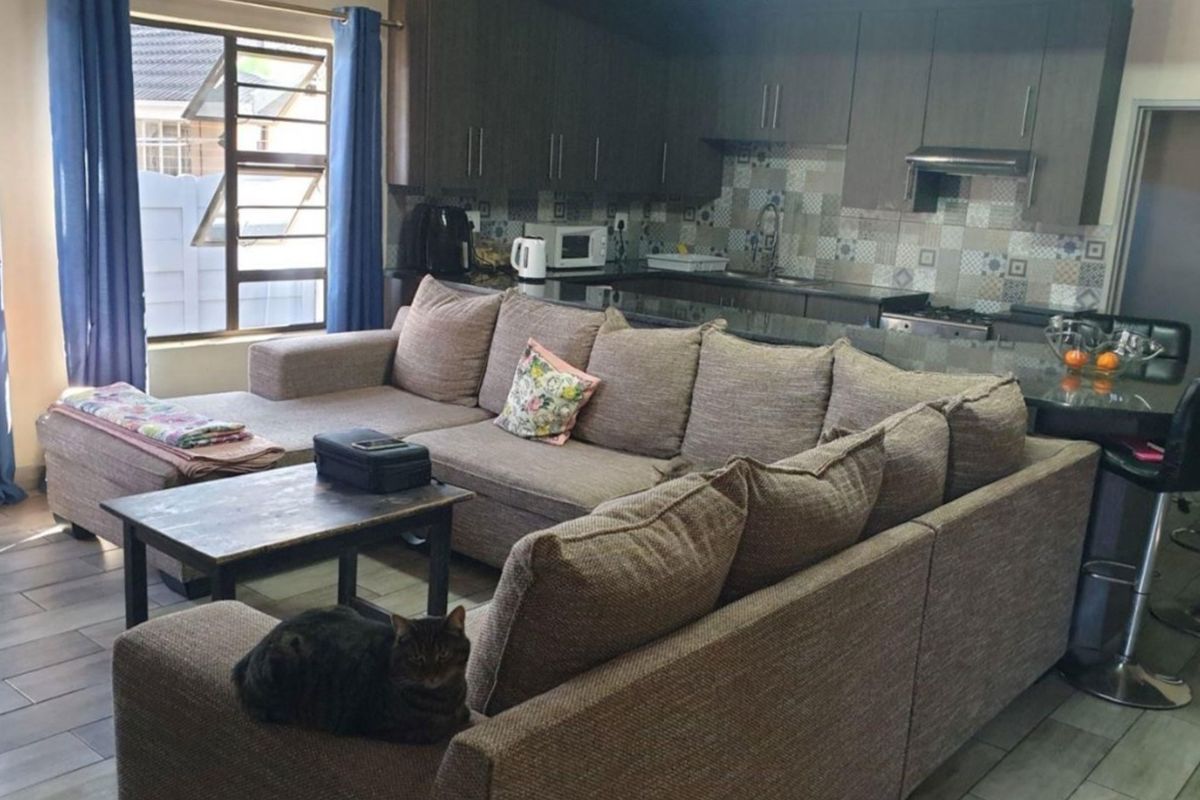 Open-plan living area featuring a modern kitchen with granite countertops, built-in cabinetry, and a breakfast bar, seamlessly connected to the lounge space.