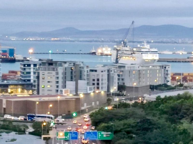 Elevated urban view overlooking the harbour, shipping vessels, and surrounding city infrastructure.