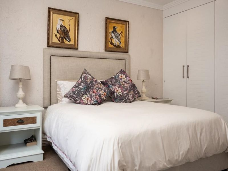 A cozy bedroom featuring built-in cupboards and neutral wall finishes, providing a comfortable and functional sleeping space.