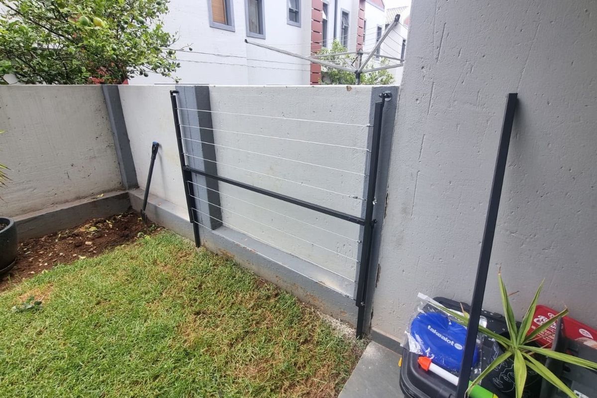 A private rear courtyard area featuring a concrete boundary wall and a fixed wall-mounted washing line.