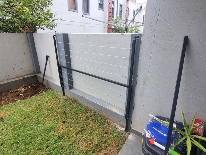 A private rear courtyard area featuring a concrete boundary wall and a fixed wall-mounted washing line.