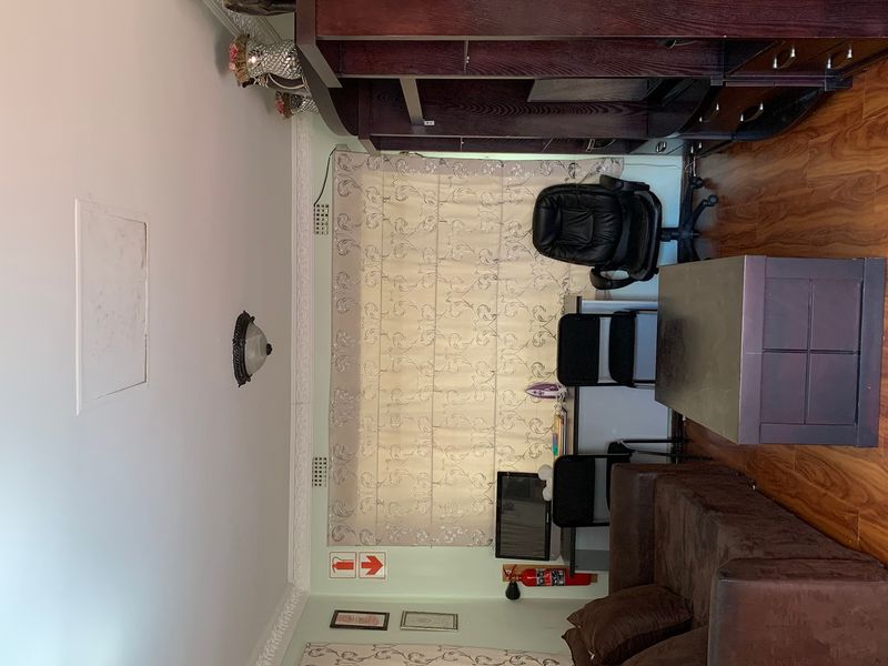 A functional office space featuring laminate flooring, decorative ceiling cornicing, and a wall-mounted fire extinguisher.