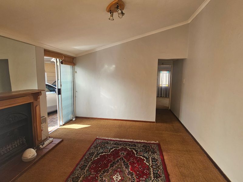 A spacious living room featuring a fireplace, carpeted flooring, and a sliding glass door providing access to the exterior.