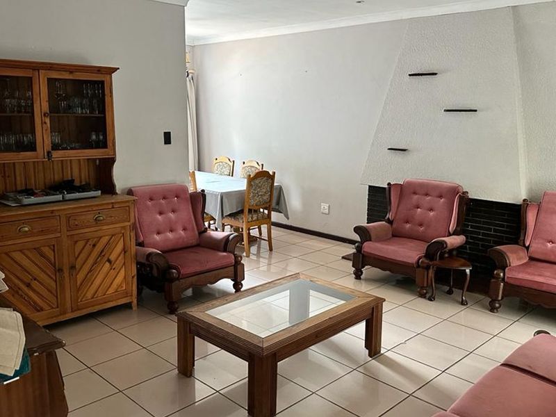 Spacious living area featuring neutral tiled flooring and a prominent built-in fireplace, offering a functional layout for comfortable family living.